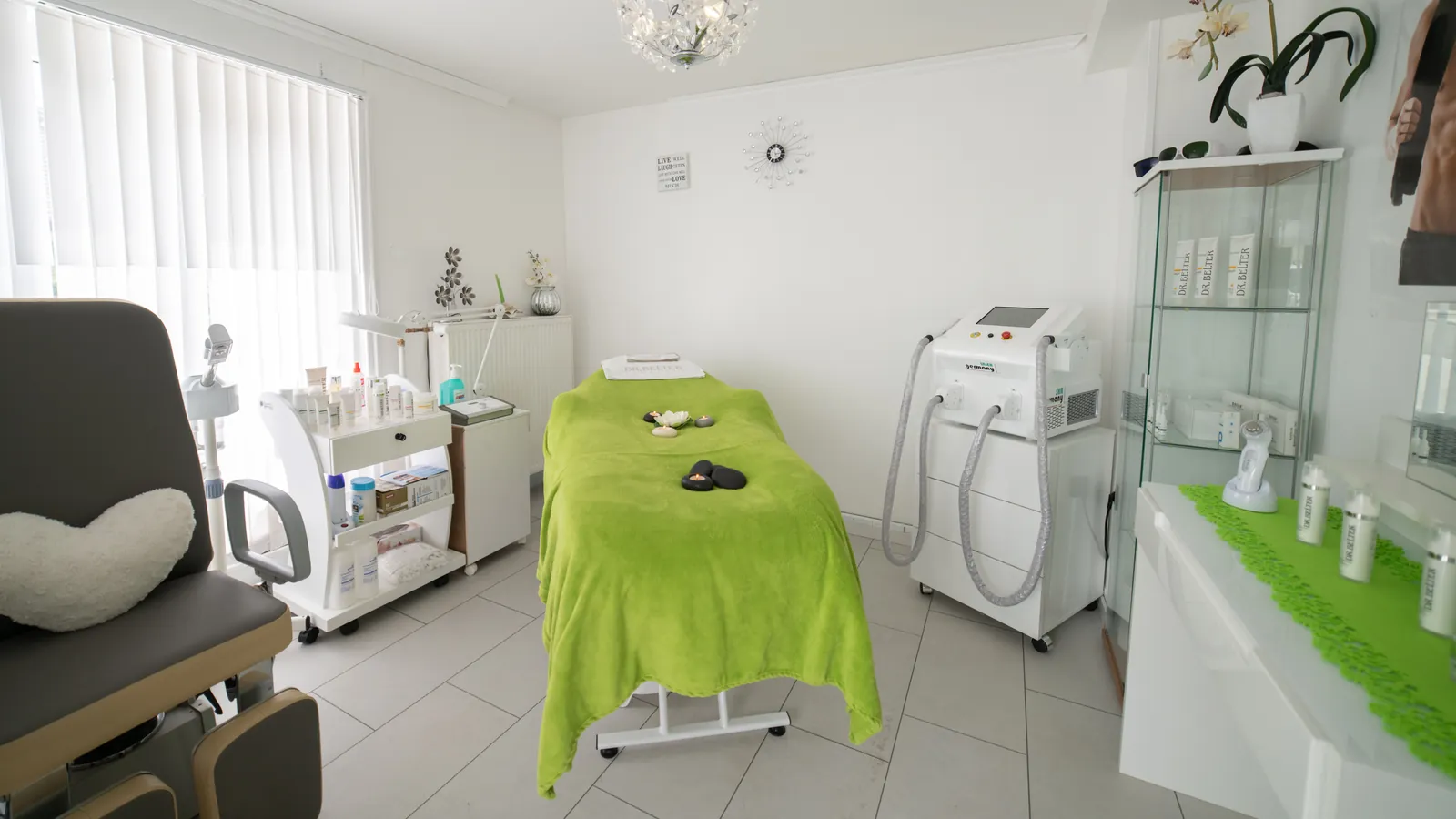 Ruang tindakan klinik kecantikan modern dengan kursi perawatan dan perangkat laser estetika
